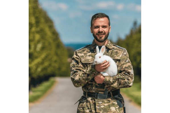 Ki-generiertes Bild von einem Soldaten mit einem weißen Hasen auf dem Arm