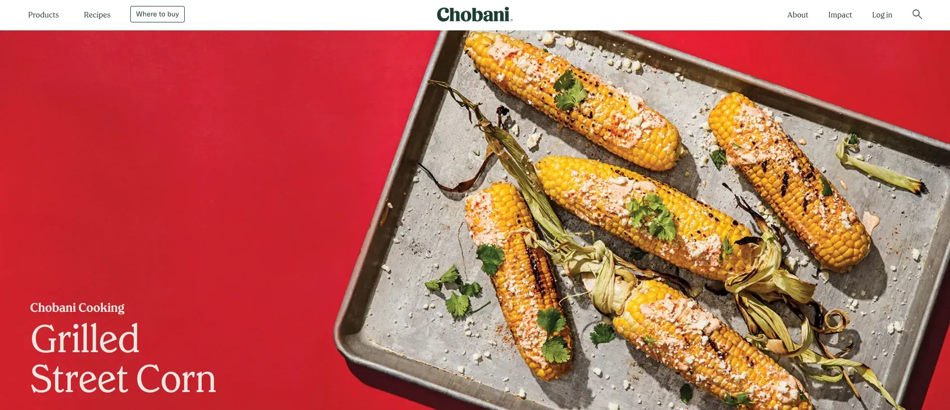 what's an entrepreneur, example of a small business entrepreneur. Chobani website homepage featuring a large photo of grilled corn on the cob on a baking sheet against a bright red background. The corn appears to be seasoned and garnished. 